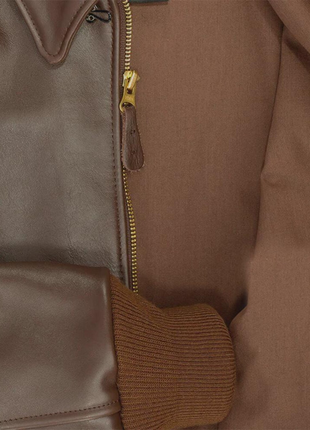 Close-up of a brown leather jacket with a zipper