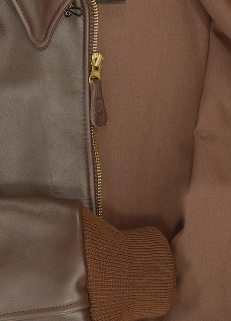 Close-up of a brown leather jacket with a zipper