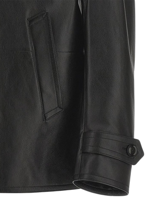 Close-up of a black leather jacket with a pocket and button detail 