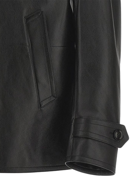 Close-up of a black leather jacket with a pocket and button detail 
