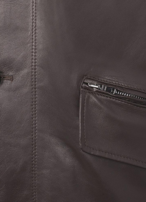 Close-up of a brown leather jacket with a button and zipper pocket.