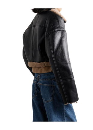 Black leather jacket with fur lining worn by a person 