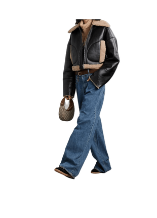 Person wearing a black leather jacket with shearling lining, blue jeans, and brown boots 