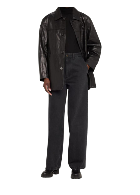 Person wearing a black leather coat over a black outfit 