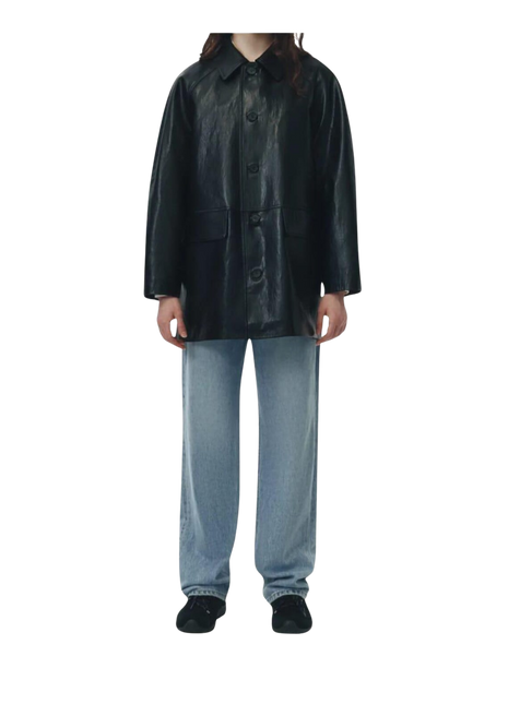 Person wearing a black leather coat and light blue pants 